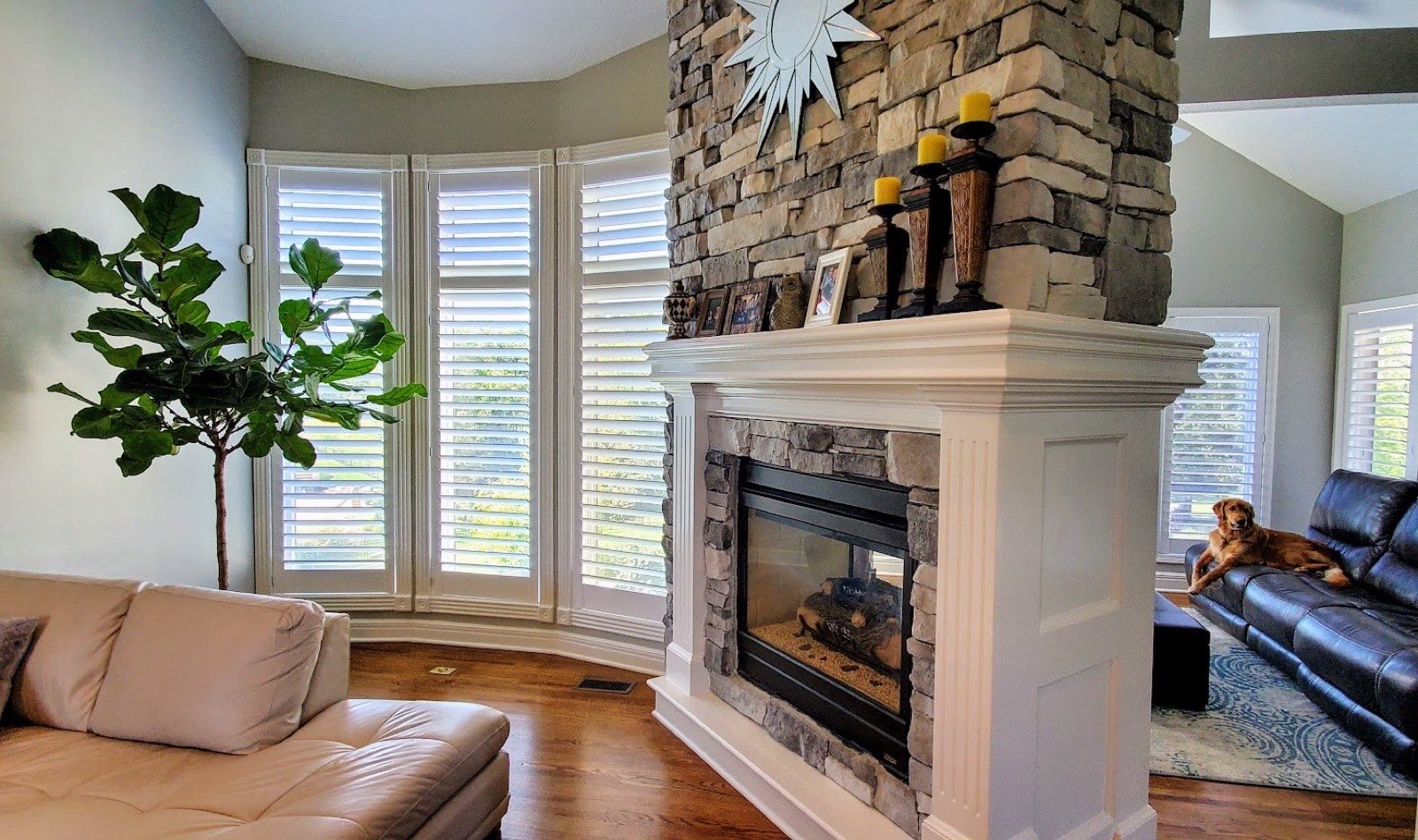 Plantation shutters on a bay window beside a fireplace